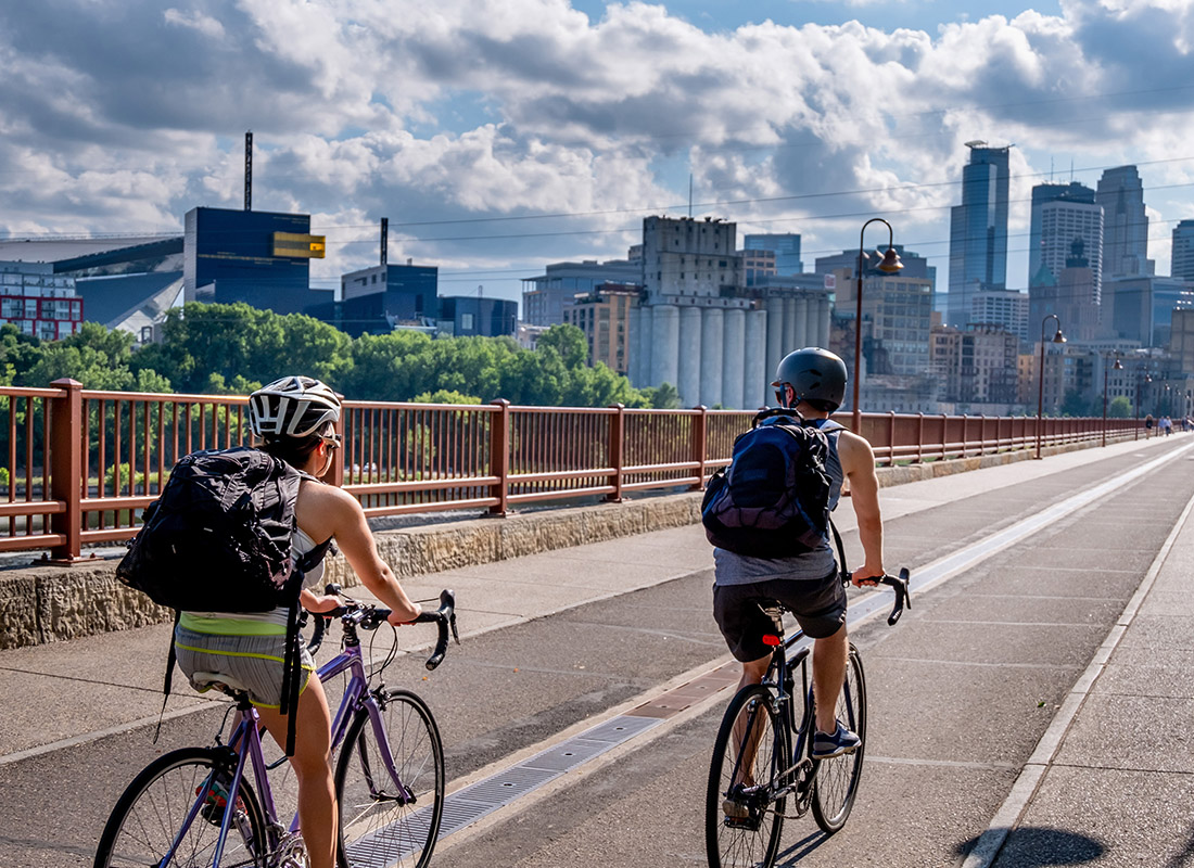 Employee Benefits - Two Bike Riders Riding Down Stone Arch Bridge in Minneapolis, Minnesota